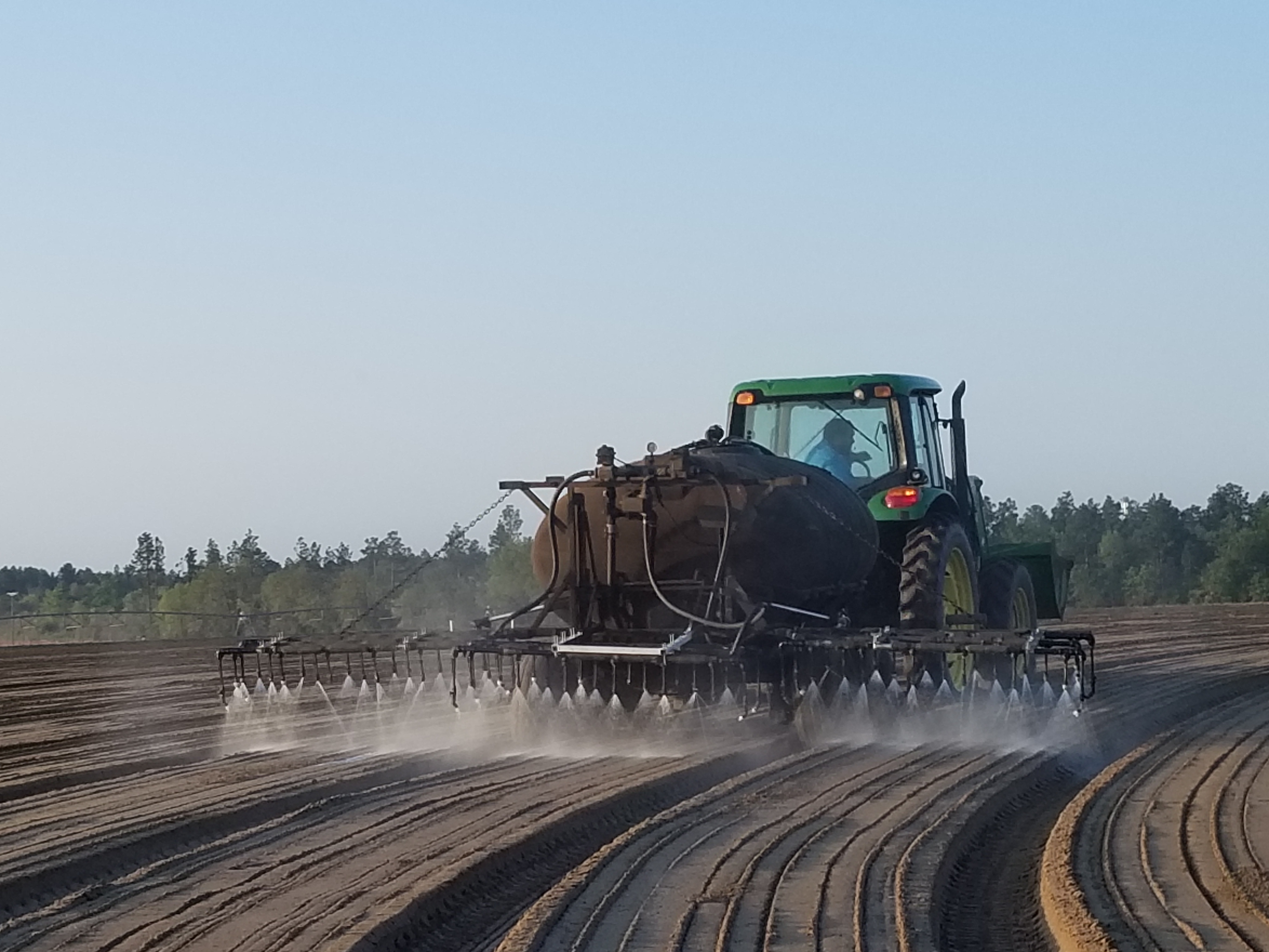 Image of Richard Fisher spraying a diluted glue mixture, which holds the bed surface intact against rain and irrigation.