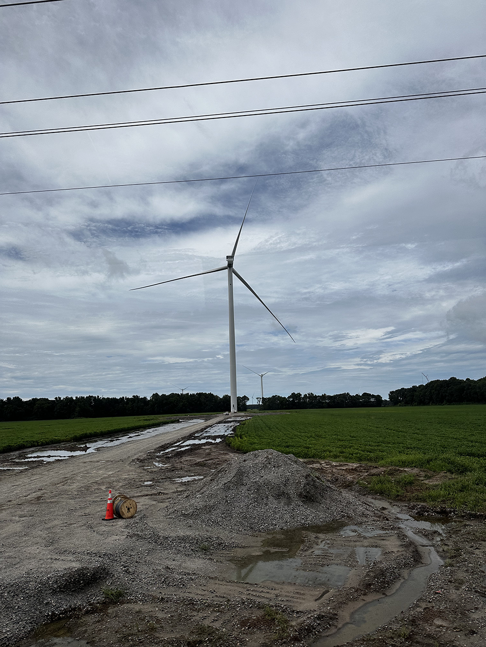 Image of a completed turbine on farmland, showing a turbine's small footprint, allowing farmers and foresters to work the land around them.