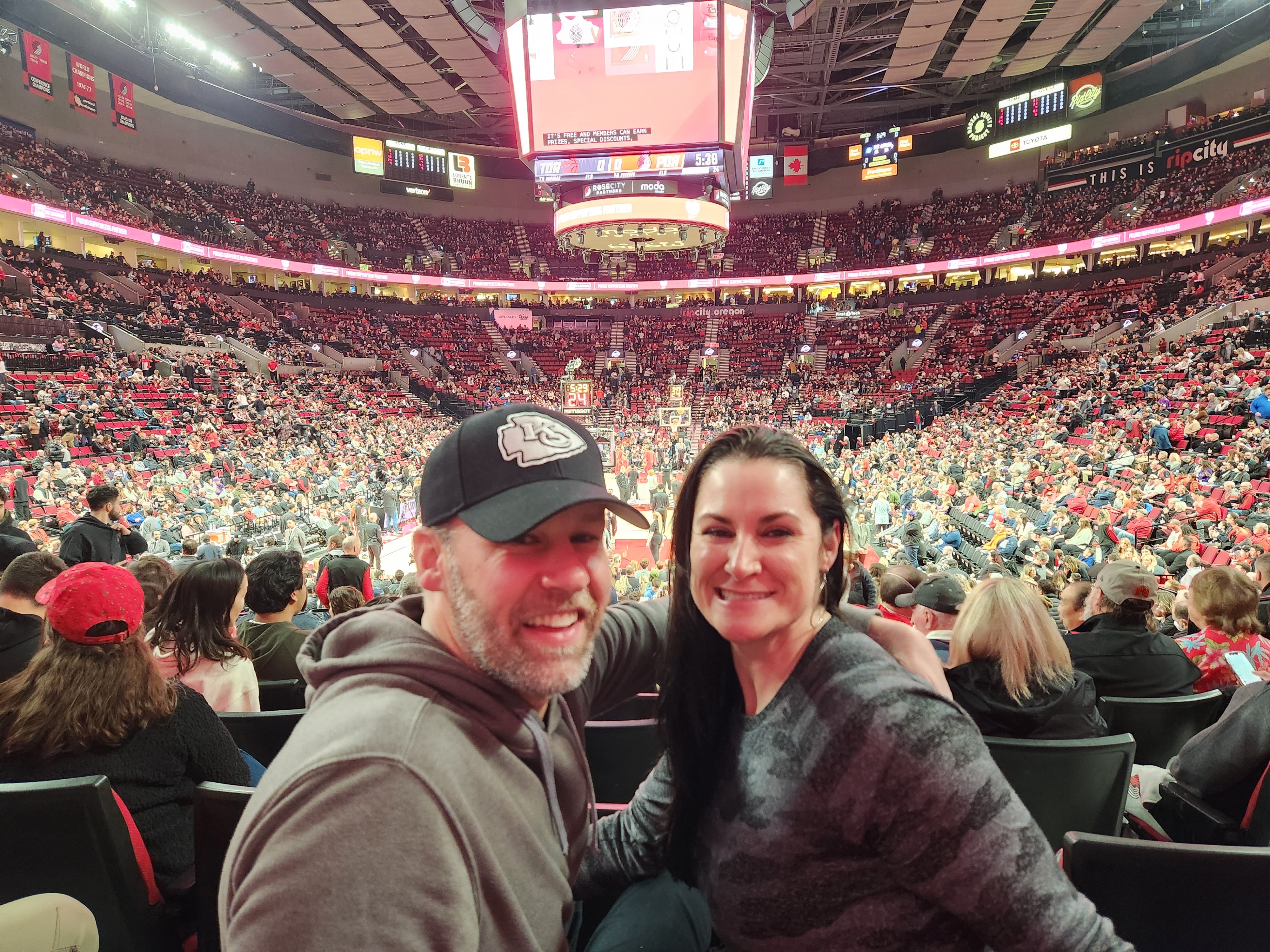 Image of Amber and her boyfriend at a Portland Trailblazers game. The picture shows both with their heads turned as the basketball court is in the background. 